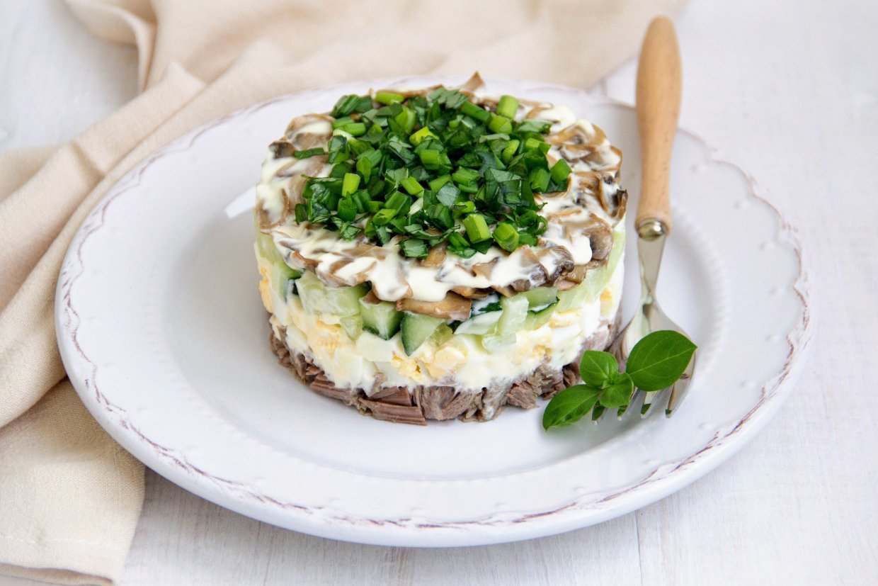 Слоеный салат с говядиной, жареными шампиньонами, огурцами и яйцами Слоеный салат с говядиной, жареными шампиньонами, огурцами и яйцами