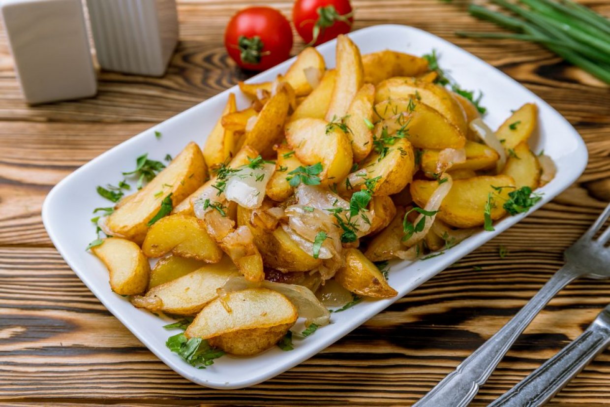 Аппетитная жареная картошка с луком и специями на сковороде Аппетитная жареная картошка с луком и специями на сковороде